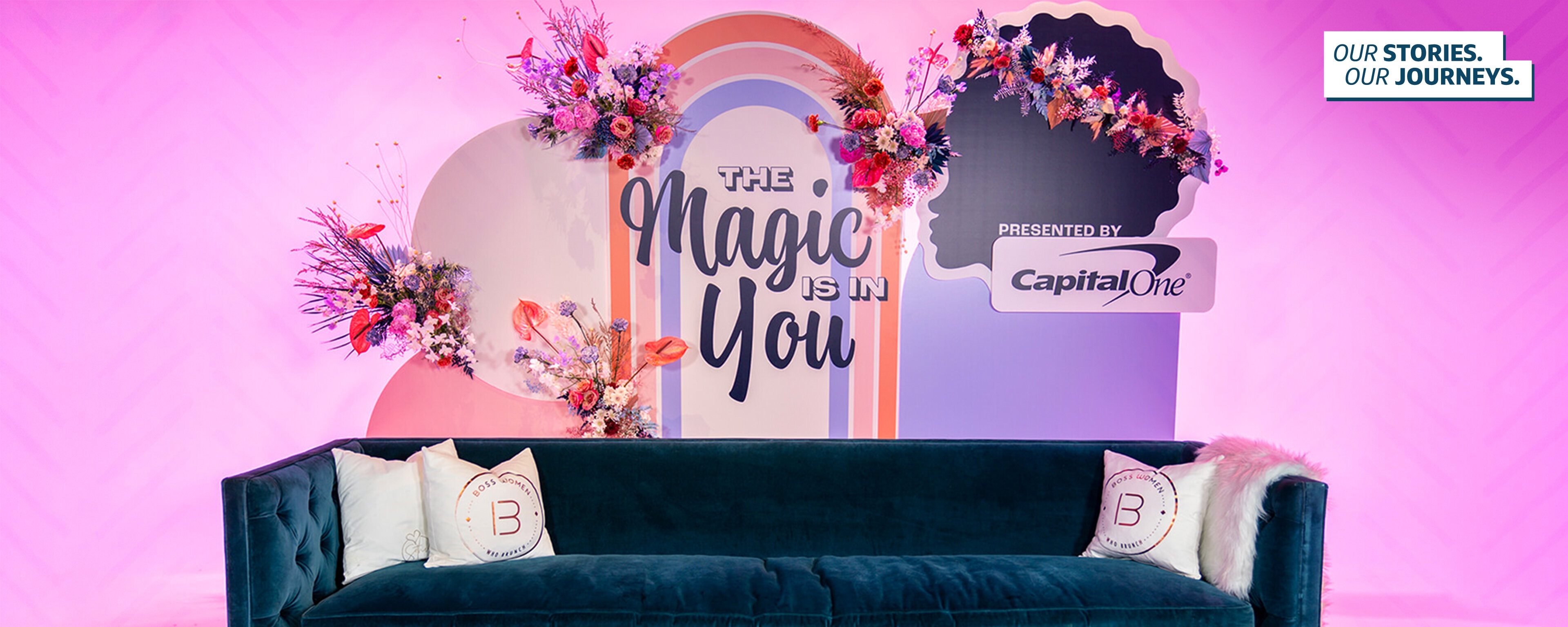 The Black Girl Magic Digital Summit Capital One set up, with a green couch in front of a pink wall and a rainbow sign with flowers that says "TheMagic in You" with a Capital One logo sign